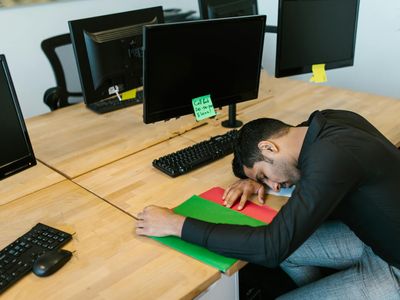 Man sitting at office desk feeling tired